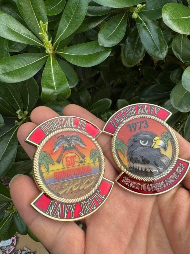 A pair of fire department badges in front of some bushes.