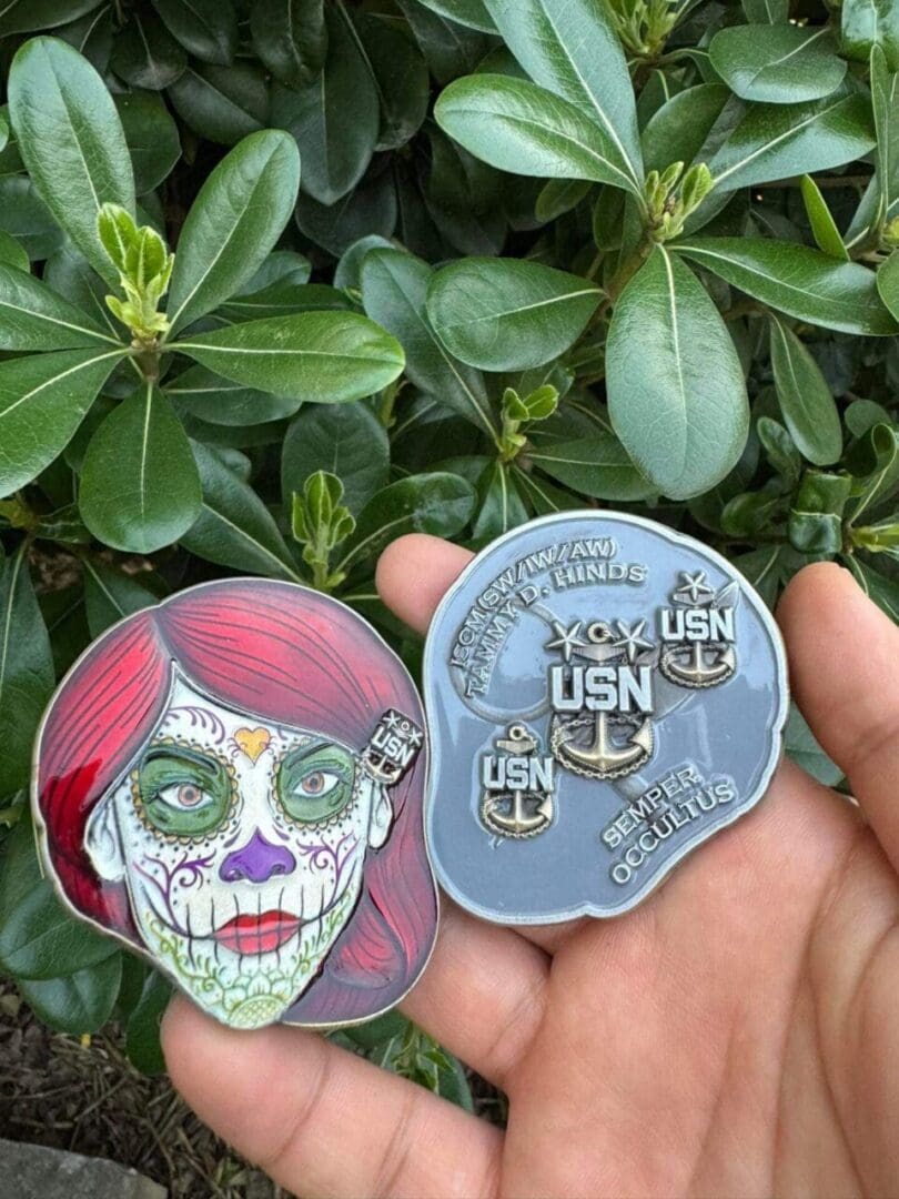 A person holding up two pins with faces on them.