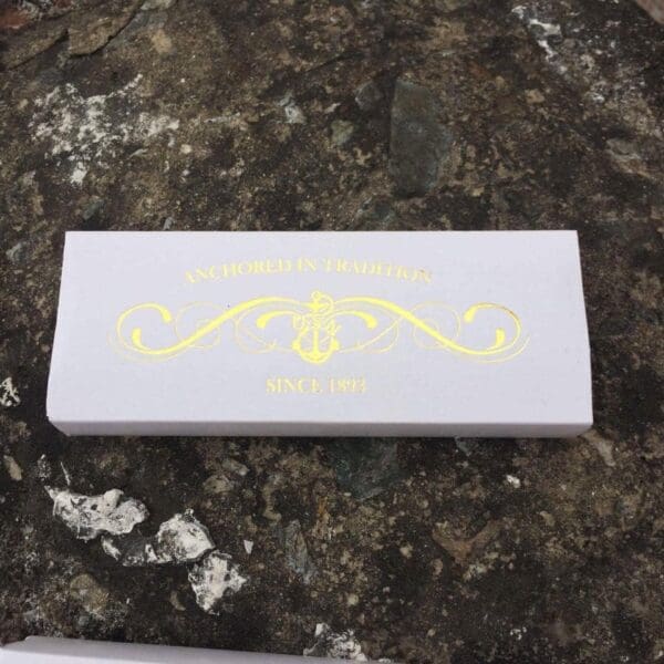 White box with gold anchor logo since 1893.