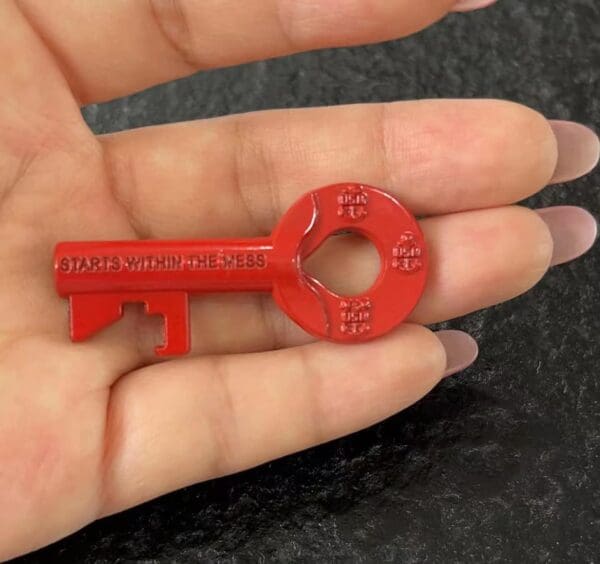 Red key with "Starts Within The Mess" inscription.