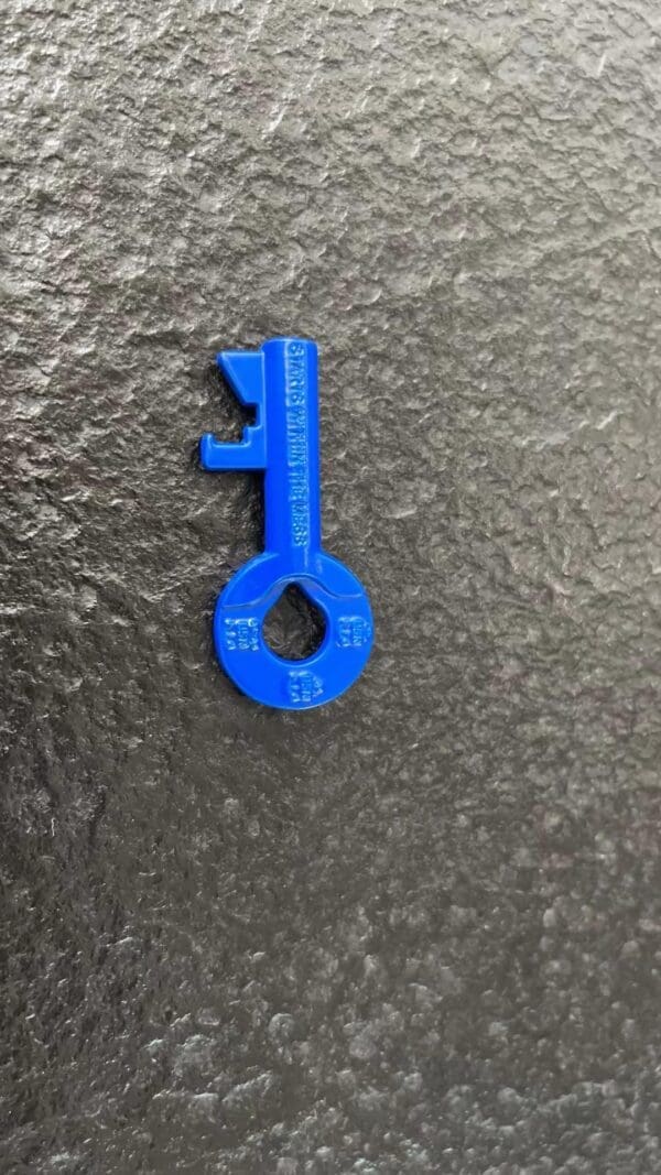 Blue plastic key on grey background.