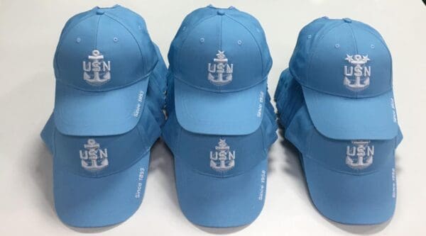 A group of blue hats with the u. S. Navy logo on them