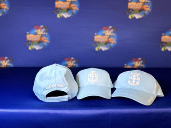 Three hats are sitting on a blue bench.