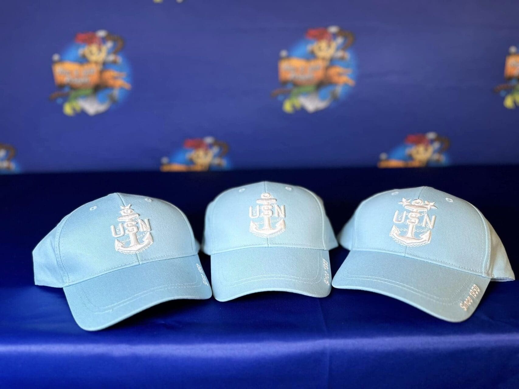 Three hats are sitting on a blue bench.