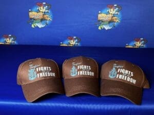 Three hats are sitting on a blue cloth.