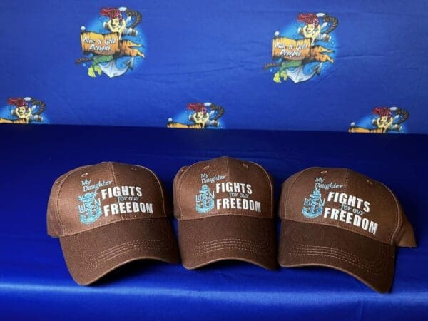 Three hats are sitting on a blue cloth.