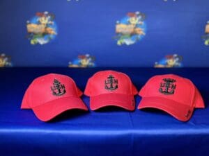 Three red hats are sitting on a blue bench.