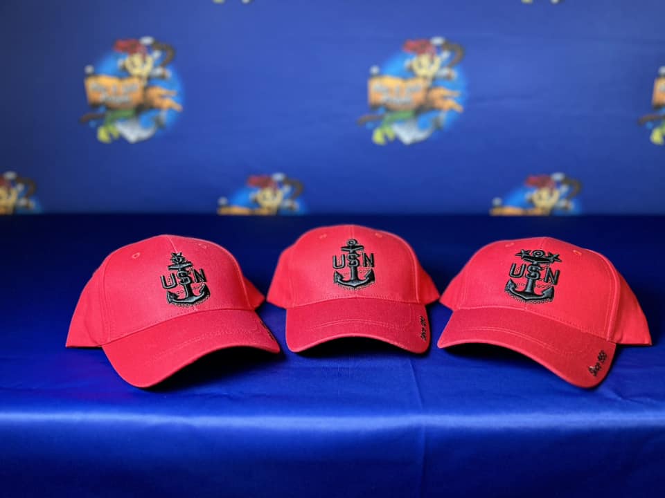 Three red hats are sitting on a blue bench.