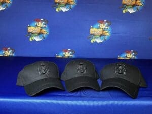 Three hats are sitting on a blue couch.