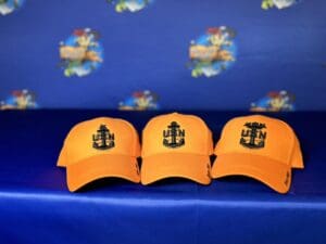 Three orange hats with a black anchor on them.