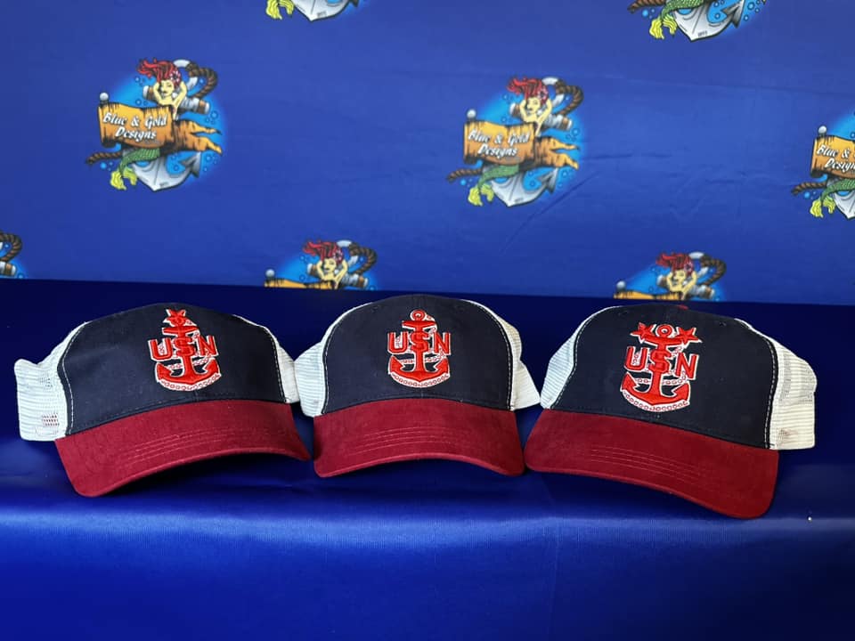 Three hats are sitting on a blue couch.