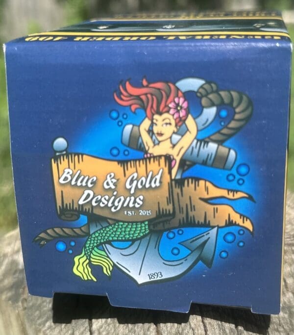 Blue & Gold Designs box with mermaid logo.